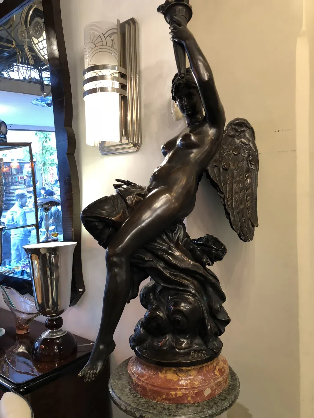 escultura antigua que representa una figura femenina con alas
