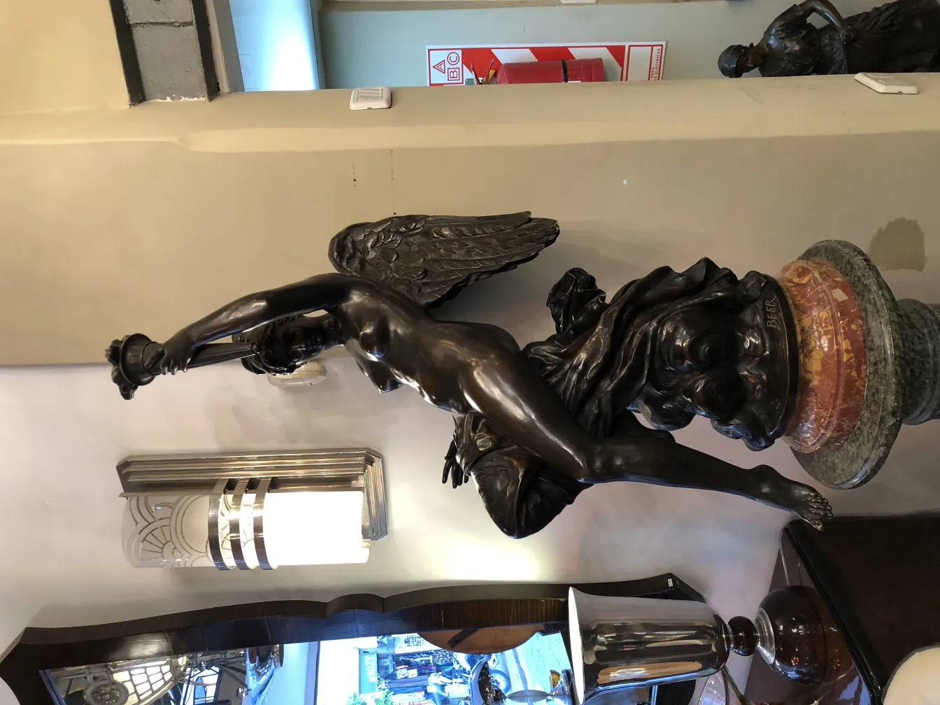 sculpture ancienne de figure mythologique avec des détails fins et une base décorative