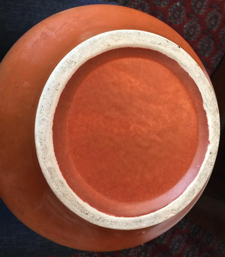 Top view of an antique red ceramic piece with a light rim.