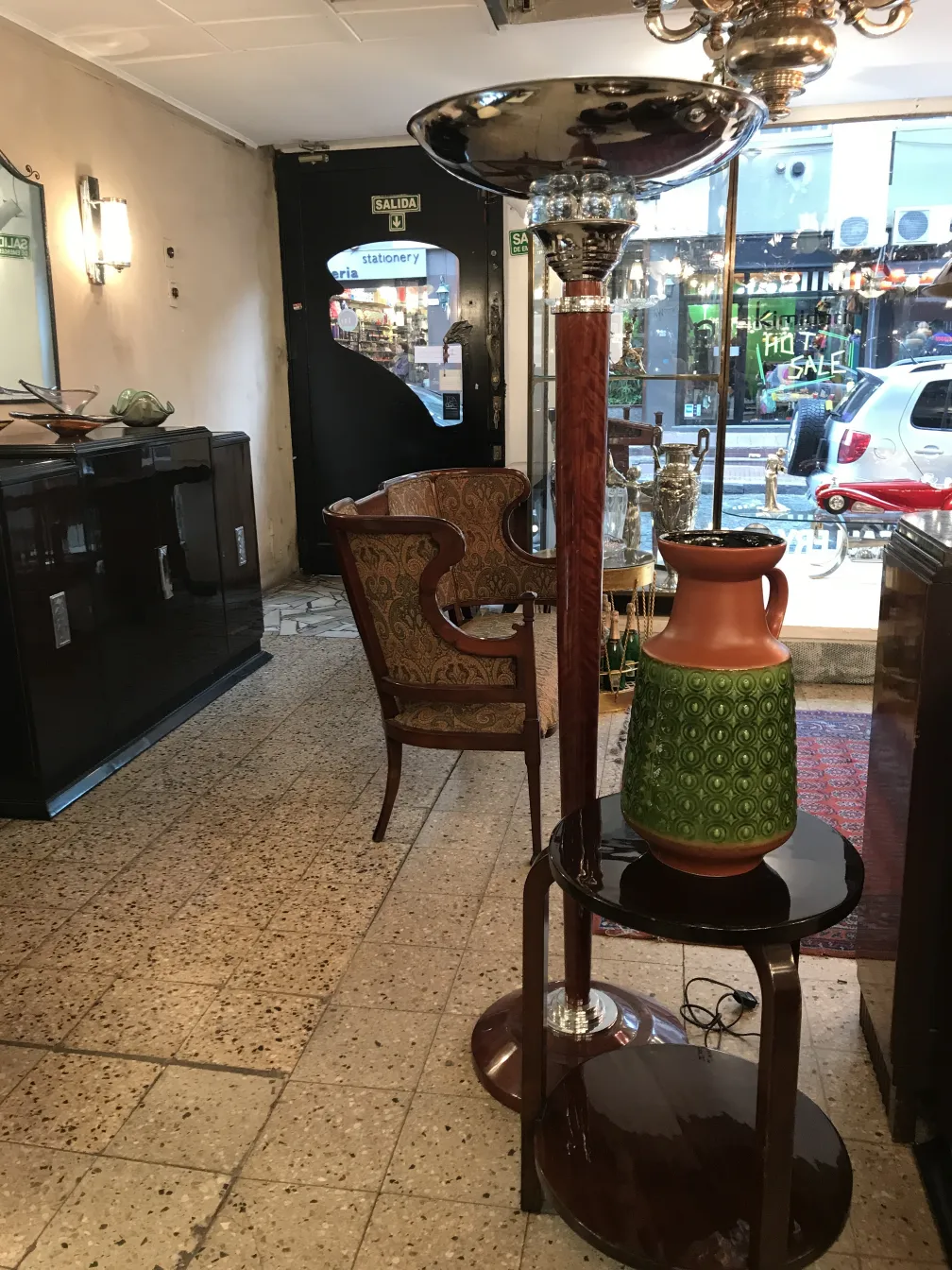 Vase en céramique ancienne avec motif vert et orange dans une boutique d'antiquités.