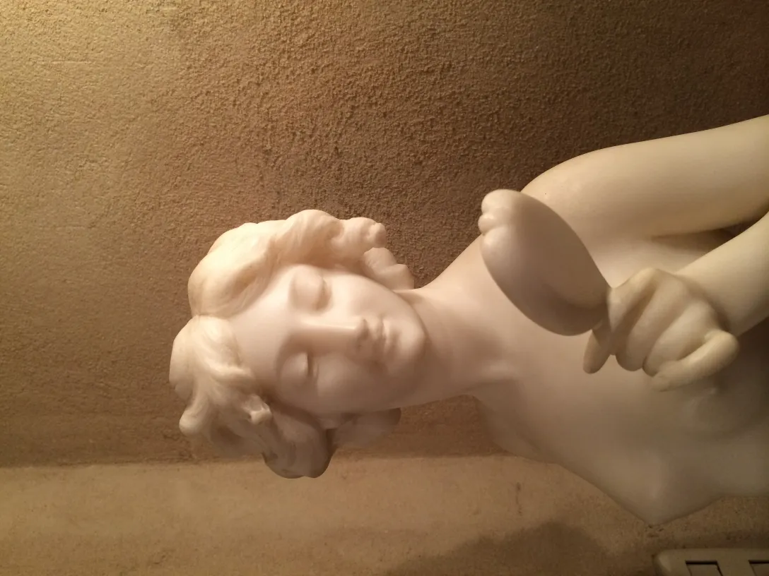 Sculpture ancienne d'une figure féminine avec des détails doux et une expression sereine.