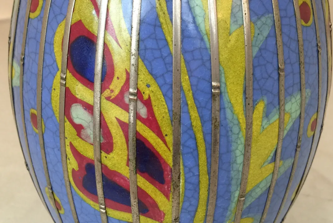 Vaso antico in ceramica colorato con disegni decorativi blu e giallo.