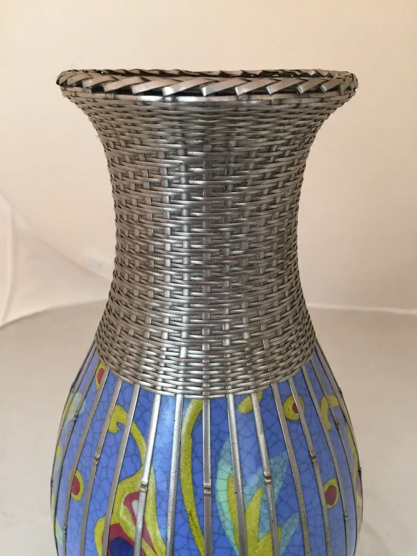 Jarrón antiguo de cerámica con decoración azul y detalles florales.