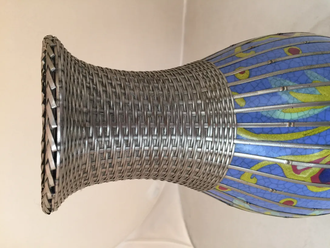 Antica ceramica colorata con dettagli accentuati e un sigillo alla base.