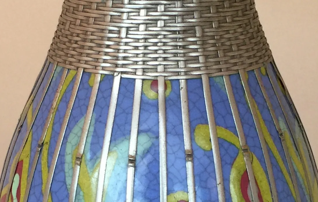 Vaso in ceramica antica con motivi colorati e texture interessanti in un ambiente morbido.