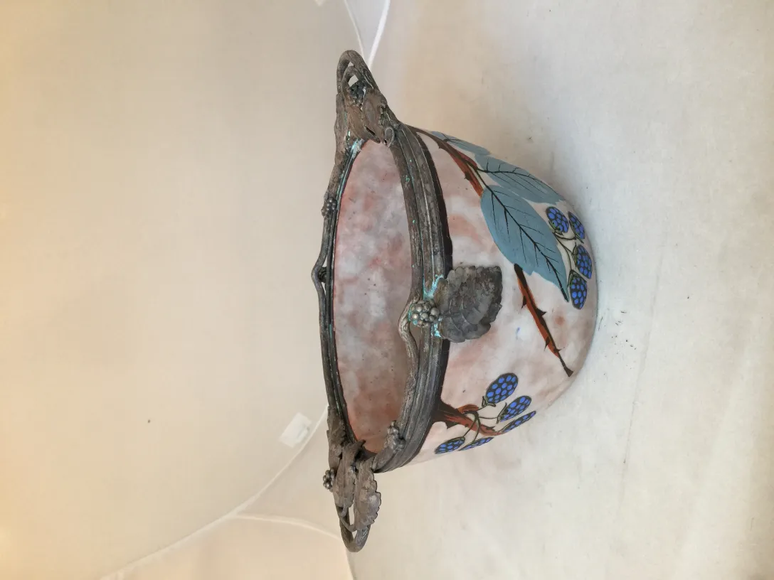 Ancient decorative ceramic featuring green leaves and blue fruits, elegant and distinctive