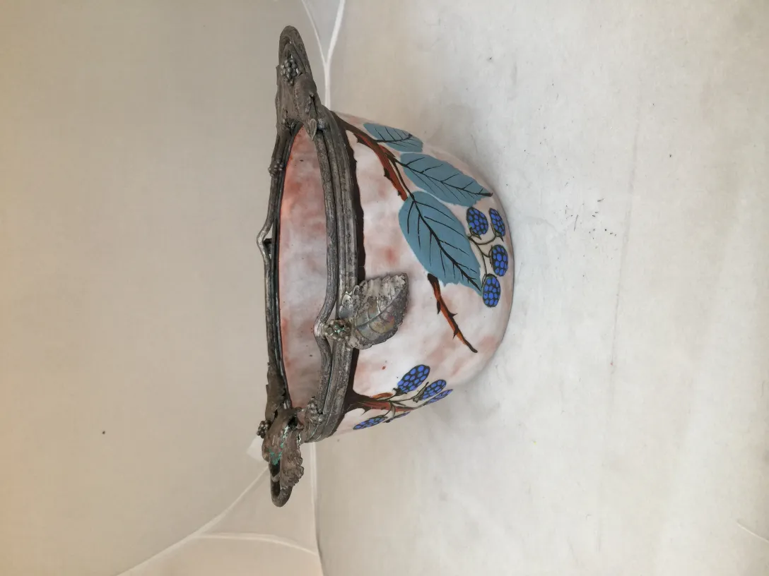 Antiga cerâmica decorada com folhas e frutos azuis.