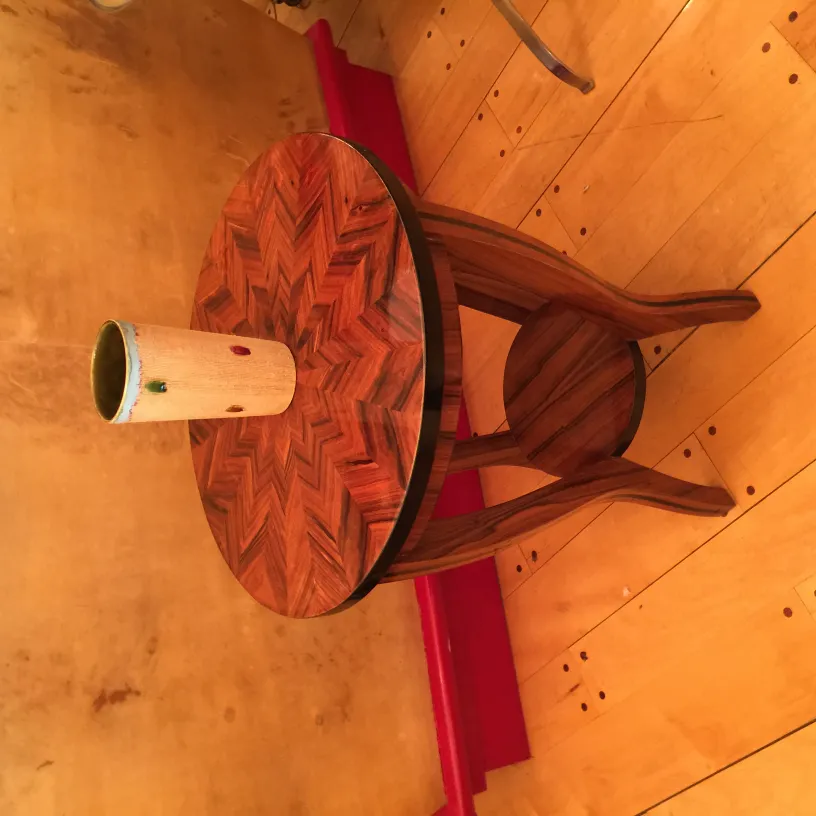 Antique ceramic vase on decorative table in warm setting.