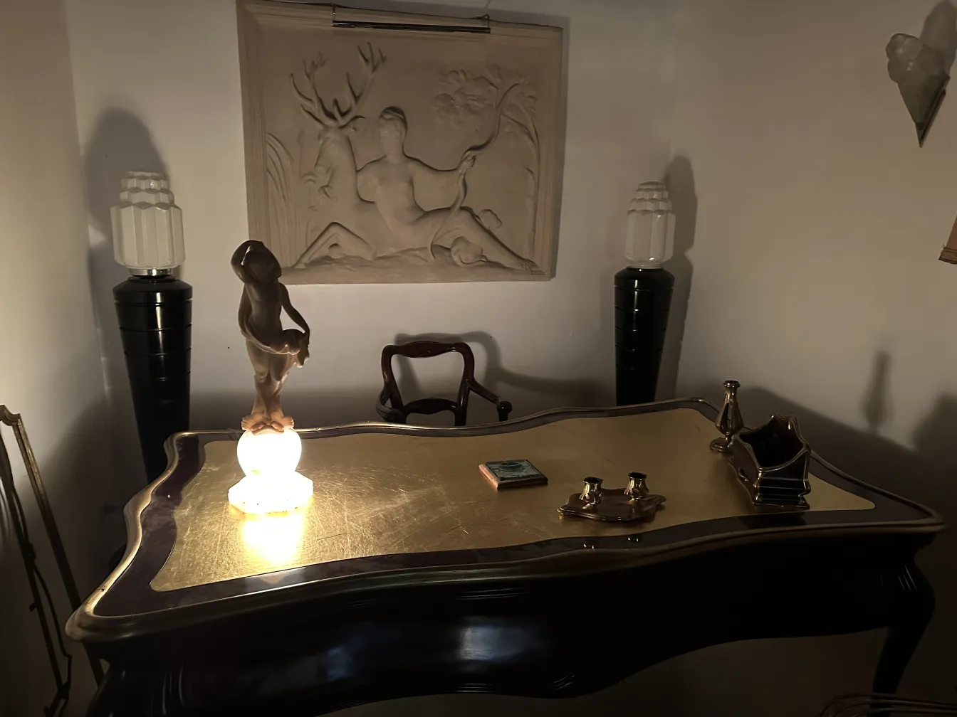 Escultura antiga de figura humana sobre uma mesa elegante.