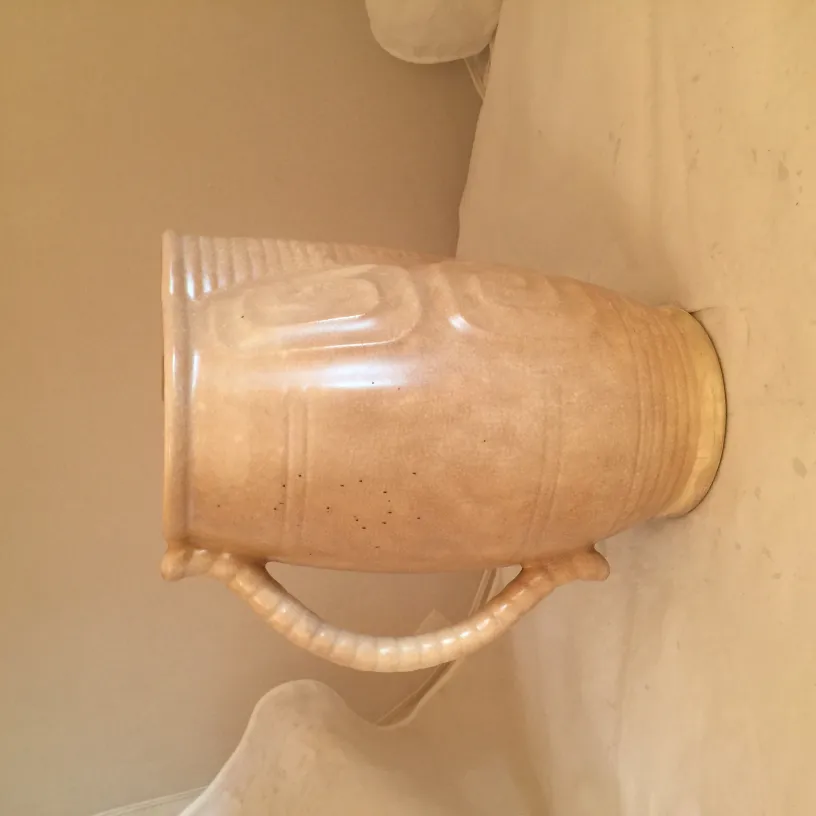 装飾的なハンドル付きの古代の陶器壺、明るい色。