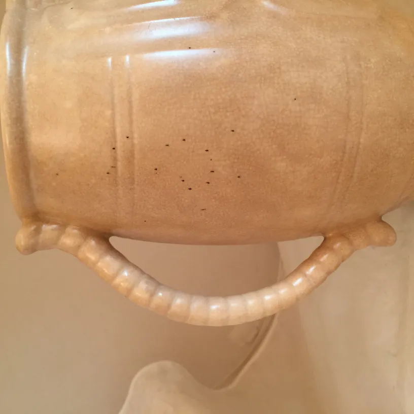 Antike Keramik-Mate mit zartem Design und hellem Farbton, sichtbar in einer frischen Umgebung.