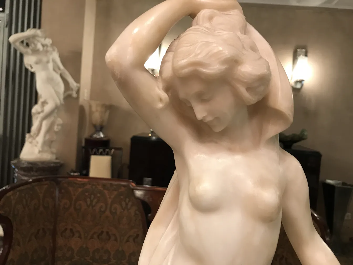 escultura de mujer con cabello ondulado en ambiente antiguo