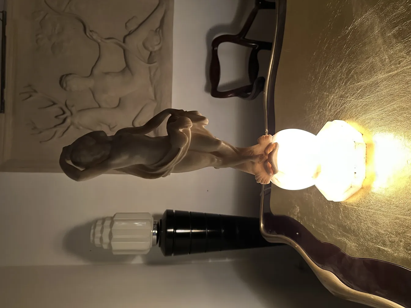 escultura figurativa antiga em uma mesa iluminada