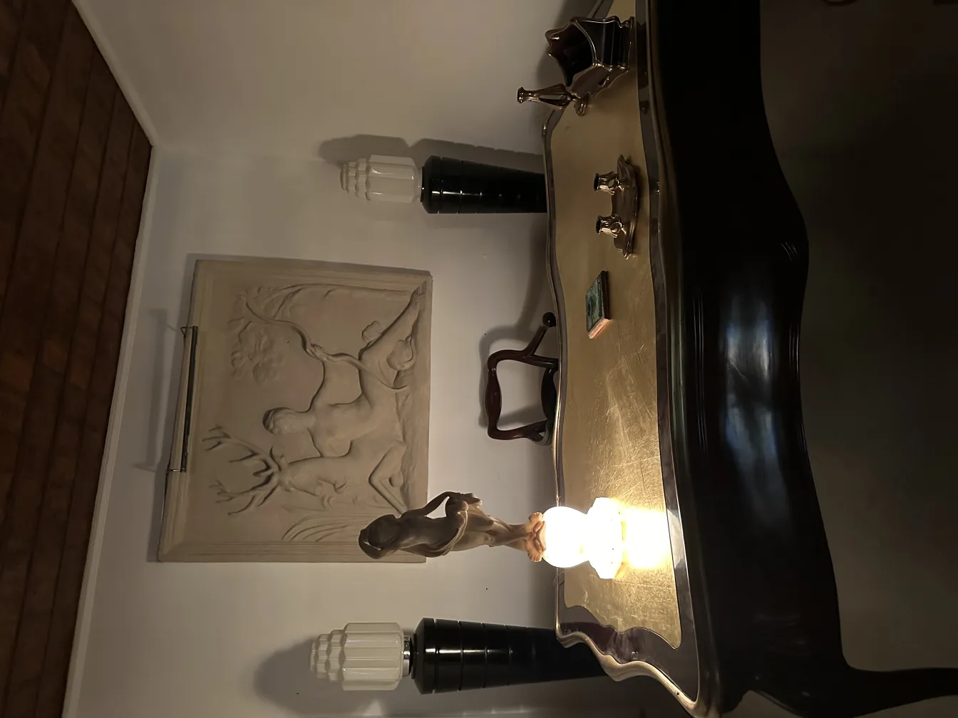 Alte Skulptur einer menschlichen Figur in eleganter Beleuchtung.