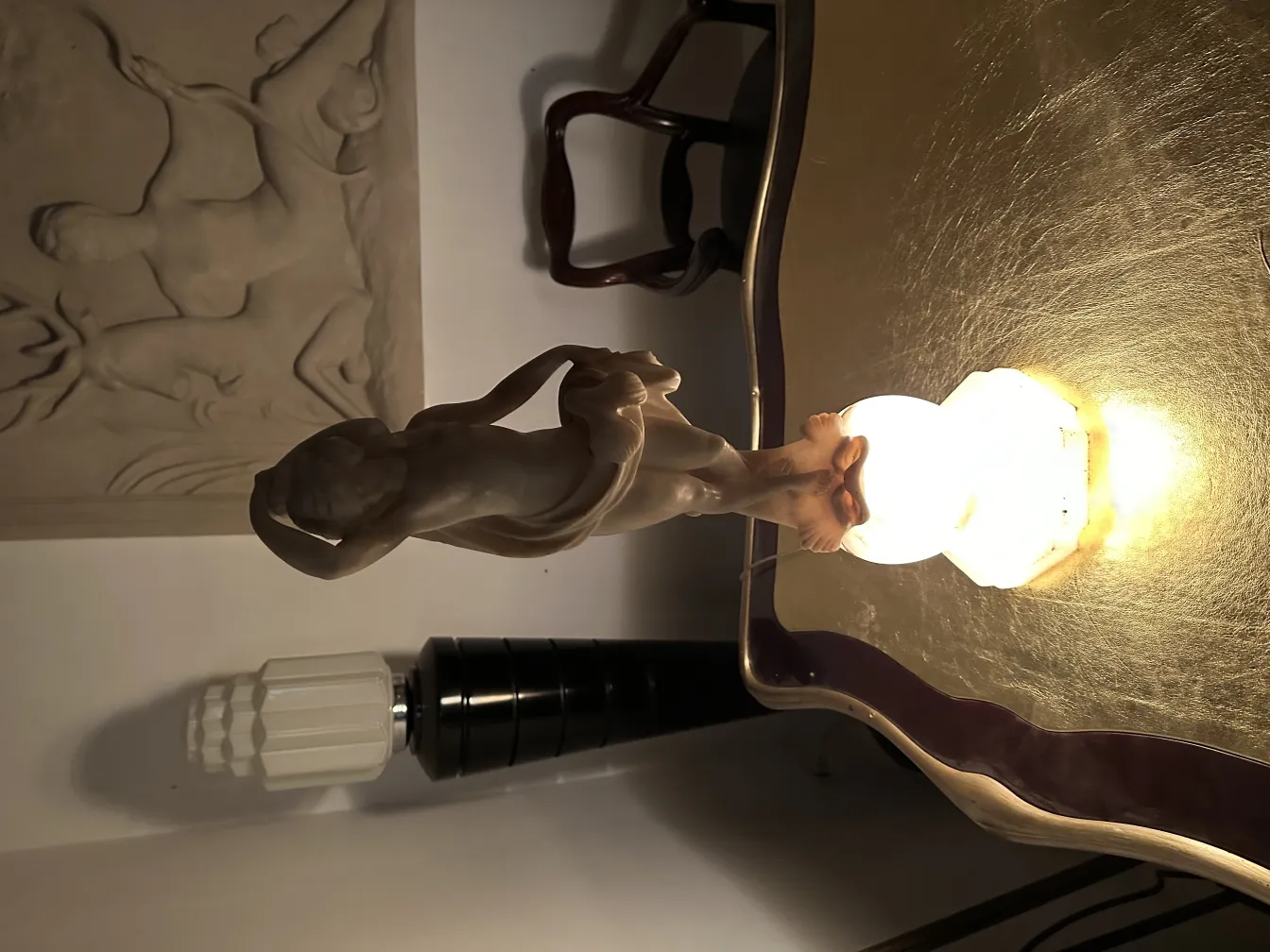 Antique decorative sculpture of a female figure in an elegant setting