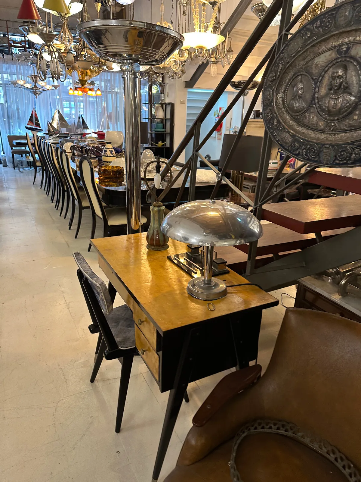 Antique yellow desk with two chairs in a bright environment.