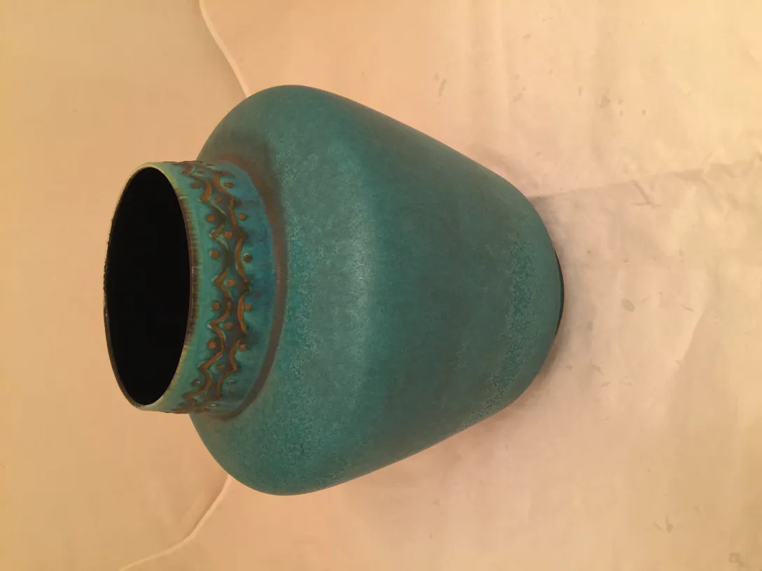 Vaso antigo de cerâmica turquesa com padrão decorativo.