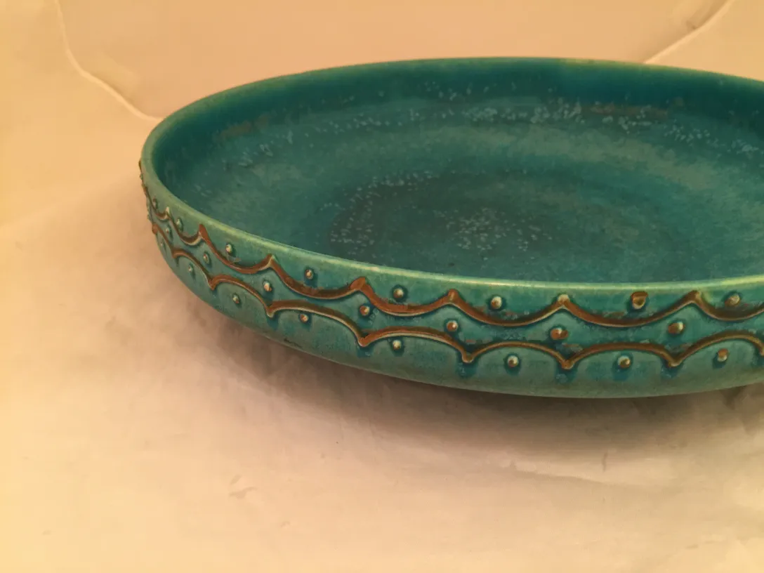 Assiette ancienne en céramique turquoise avec motifs. Arrière-plan doux.