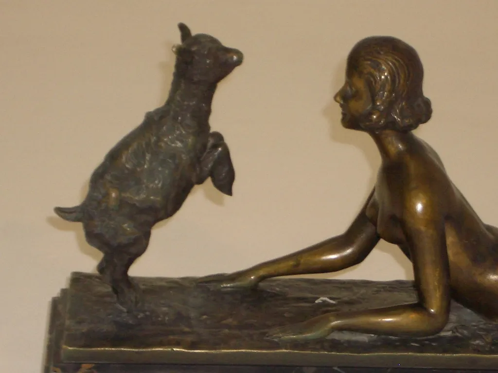 escultura antigua de joseph-daste con figura femenina y cabra en un entorno neutro