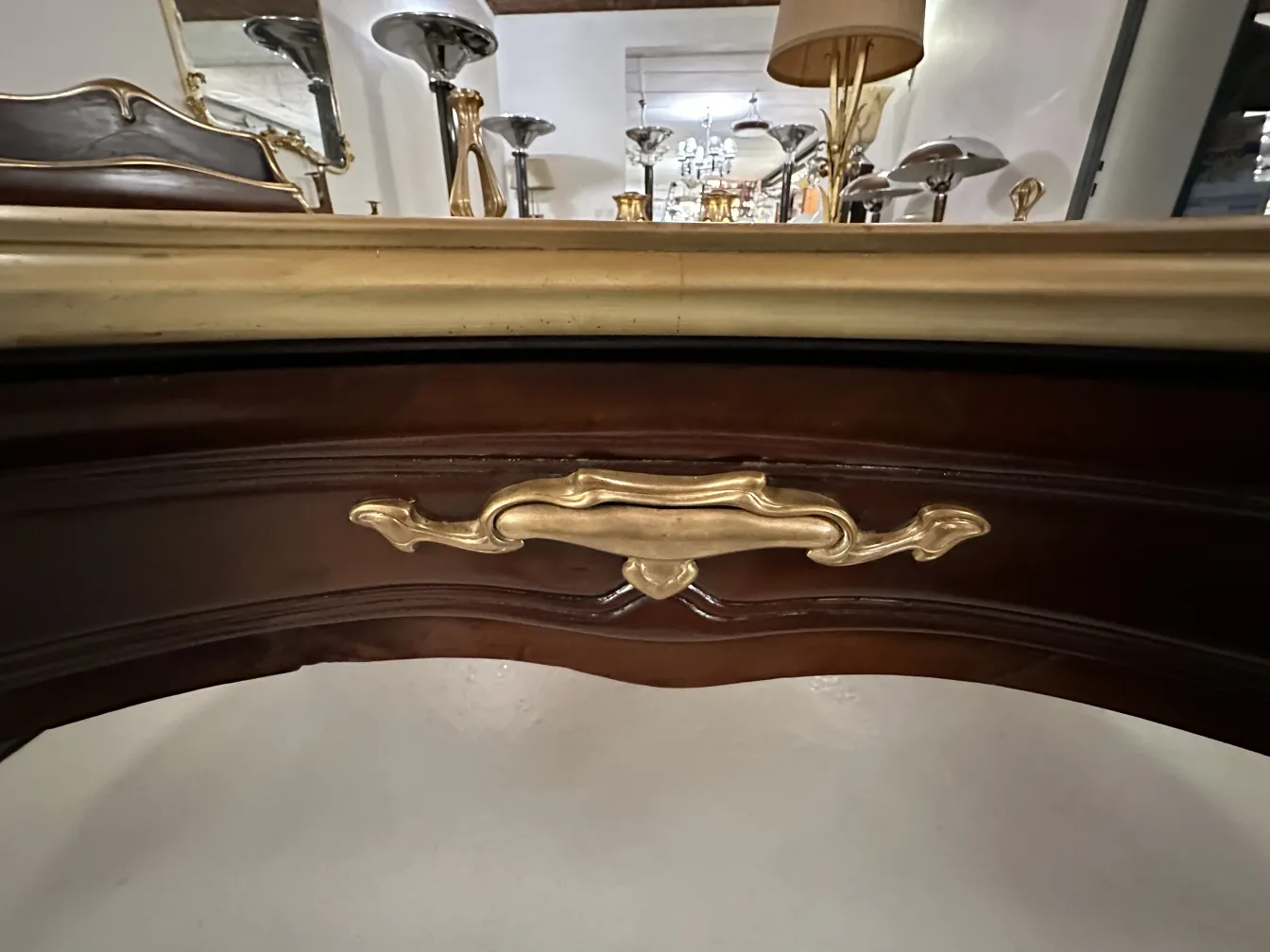 Vue détaillée d'un bureau ancien de Gustave Keller avec des détails dorés sur la poignée dans un cadre élégant.