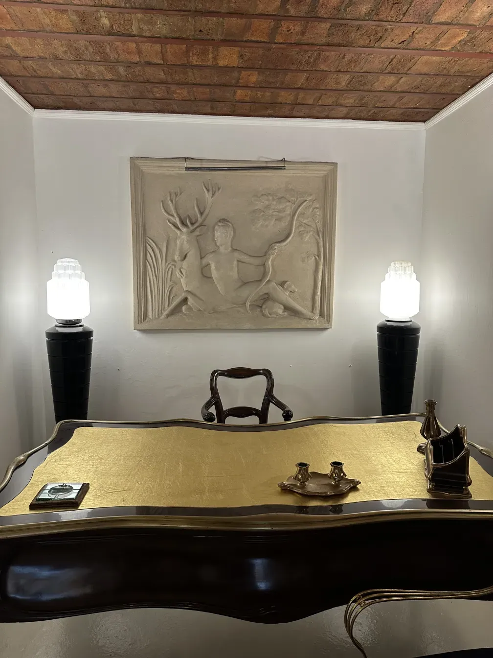 Escritorio antigo decorativo de Gustave Keller em Orfevre, 22 rue Joubert. Destaca pela sua superfície dourada e itens decorativos.