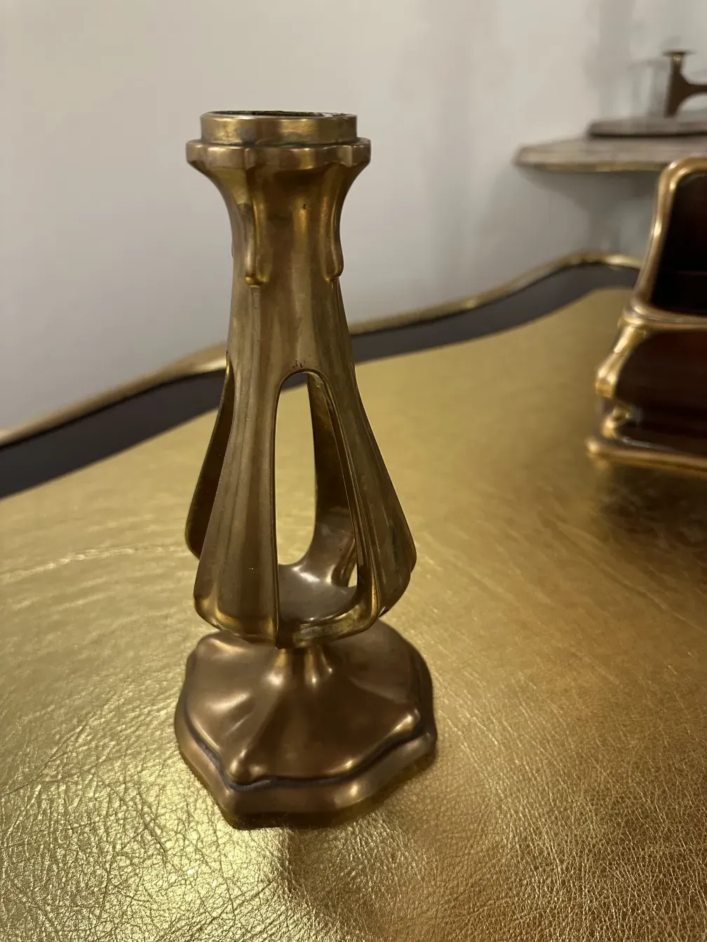 Candelabro antigo sobre uma mesa de escritório em um ambiente clássico.
