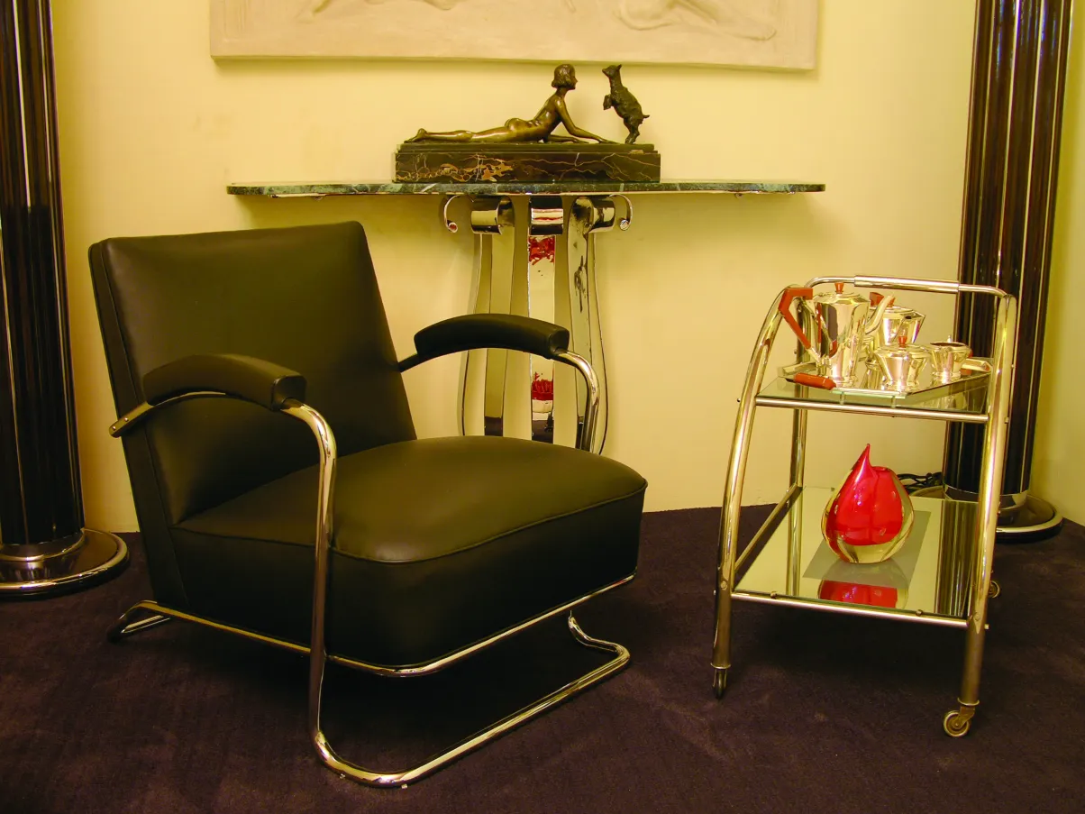 elegant antique sculpture with chair and table in view