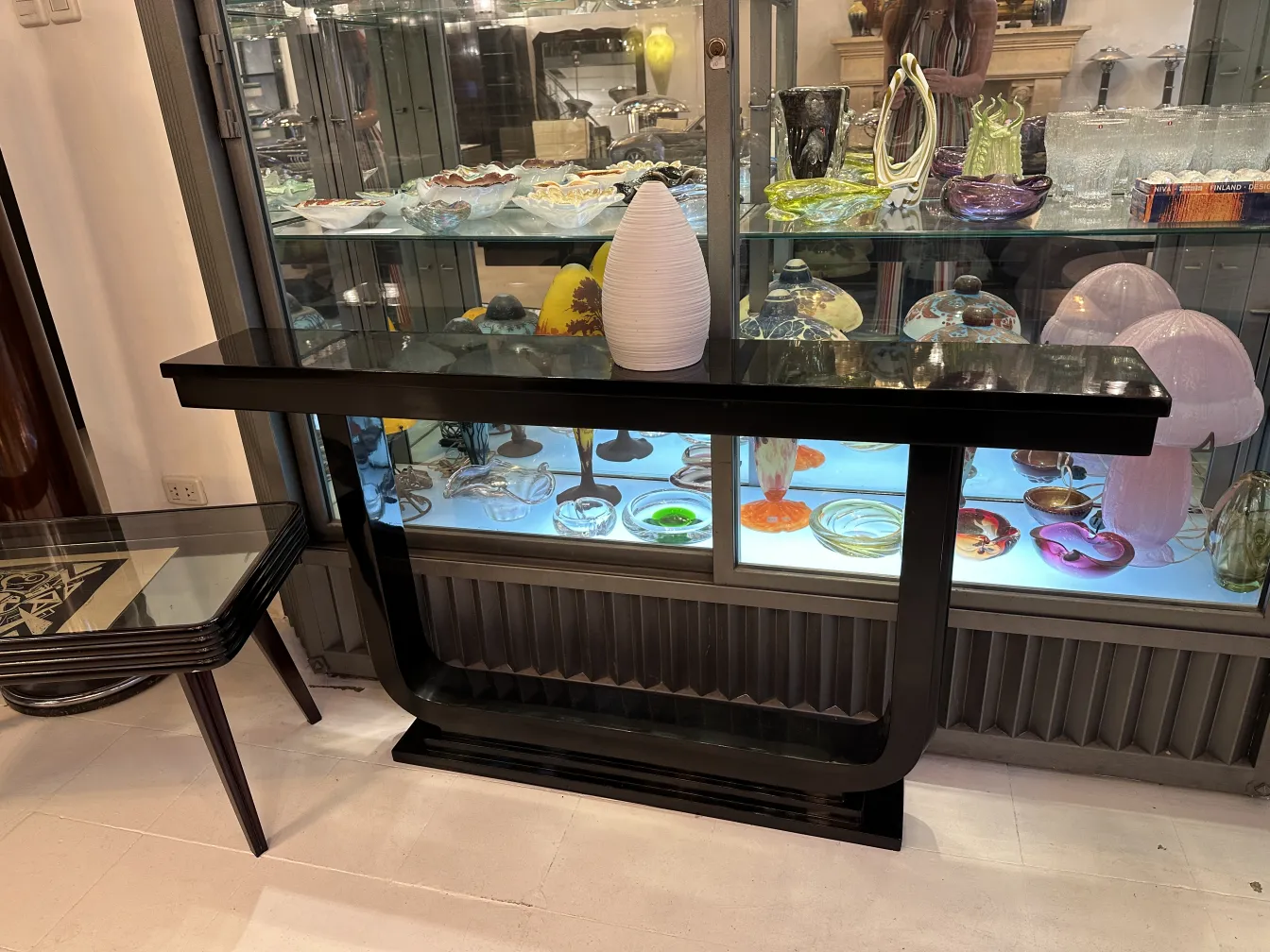 White ceramic vase on black table with glass showcases