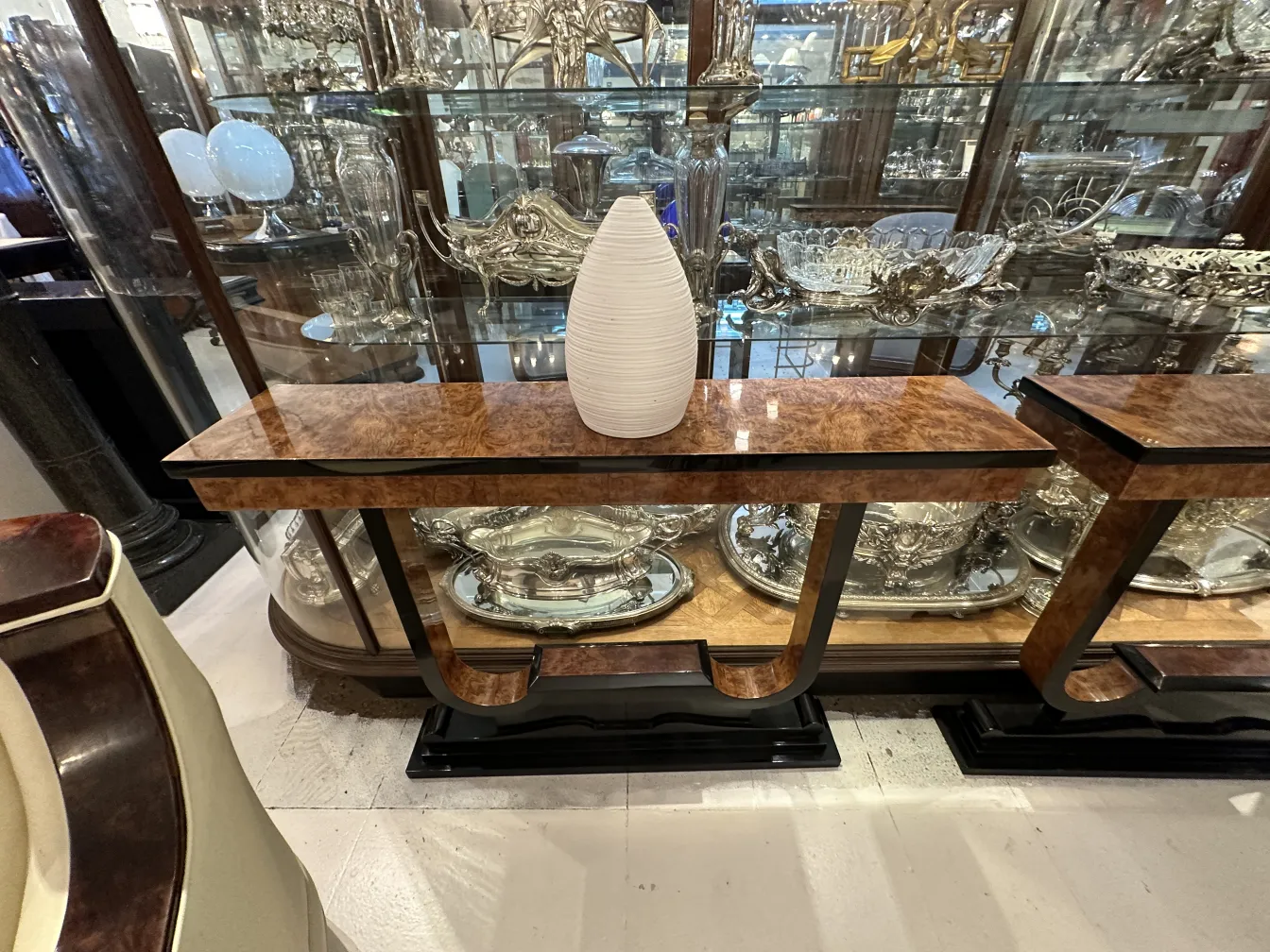 Jarrón de cerámica antigua sobre mesa, fondo con plata