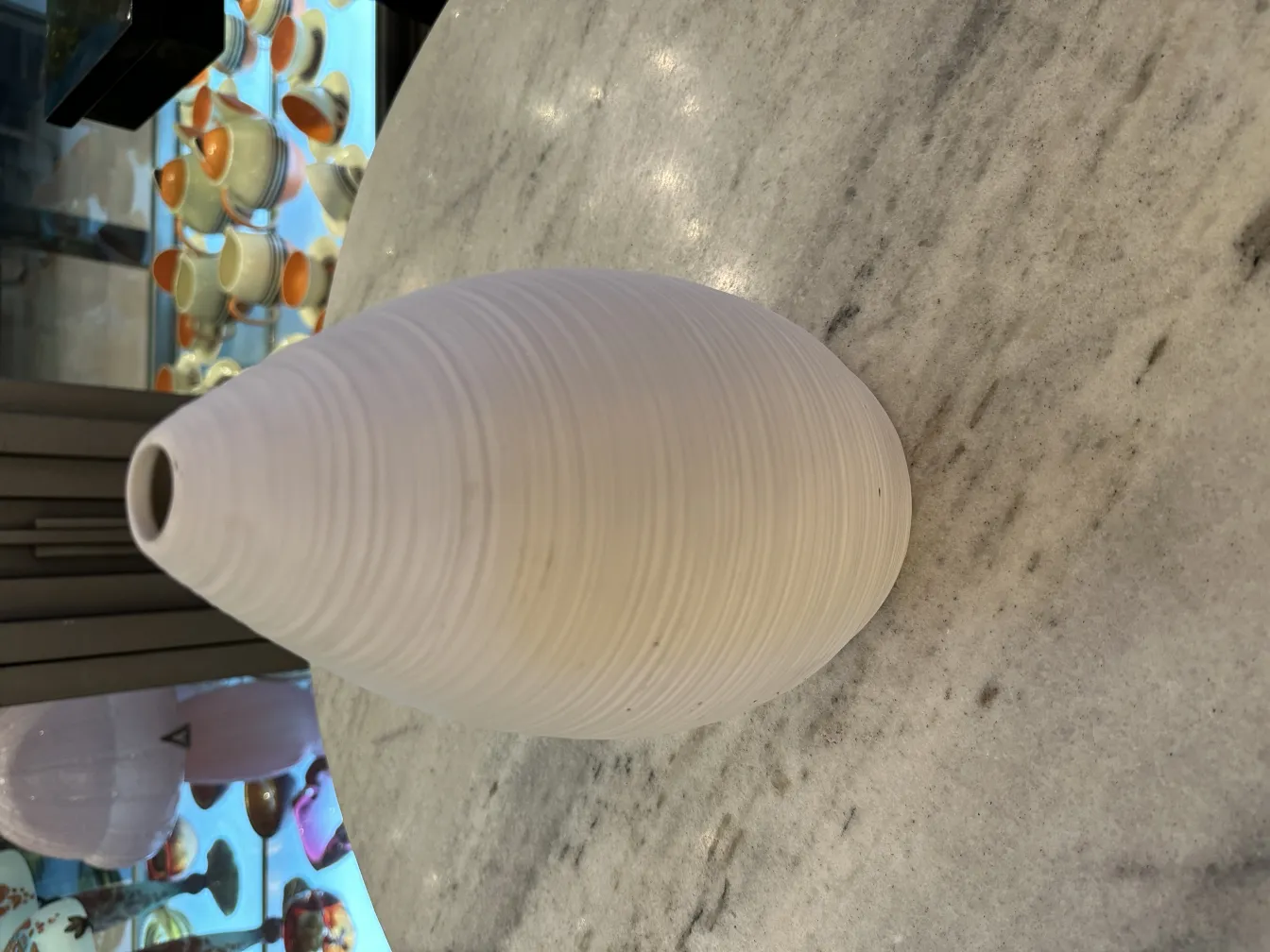 Antique ceramic vase in spherical shape on marble surface