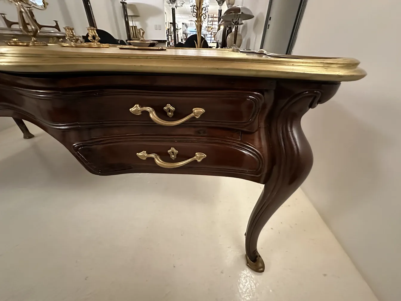 escritorio antiguo de Gustave Keller en Orfevre, con diseño curvado y tiradores dorados.