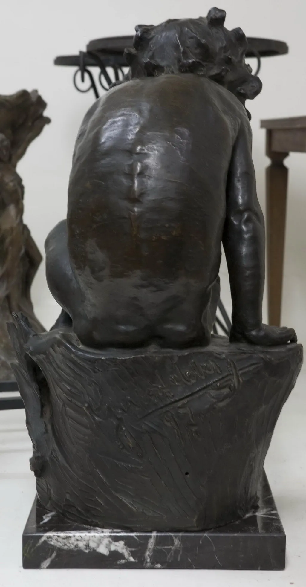 antike skulptur einer menschlichen figur von hinten, details am sockel