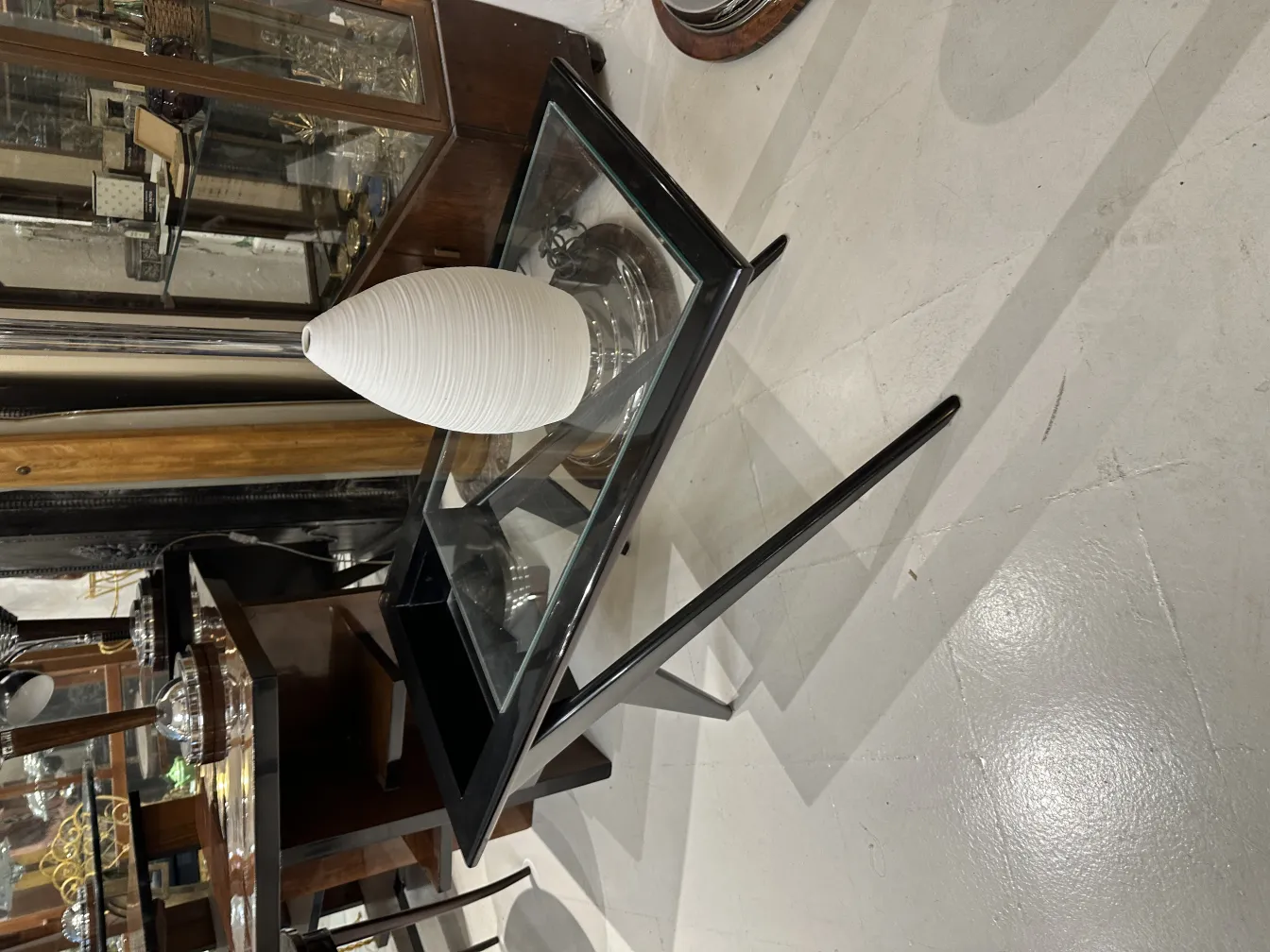 Antique white ceramic vase on a glass table.