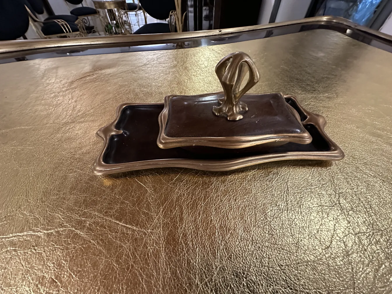 Scrivania antica con design elegante di Gustave Keller e vassoi decorativi su sfondo dorato.