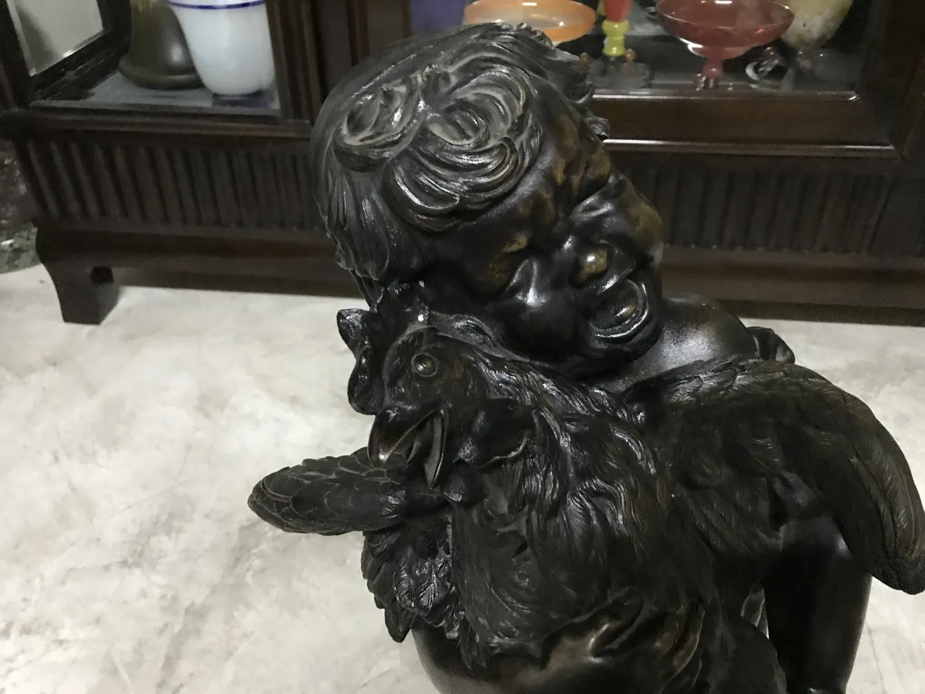 고대 조각상이 새를 들고 있는 어린이 형상을 보여줍니다.