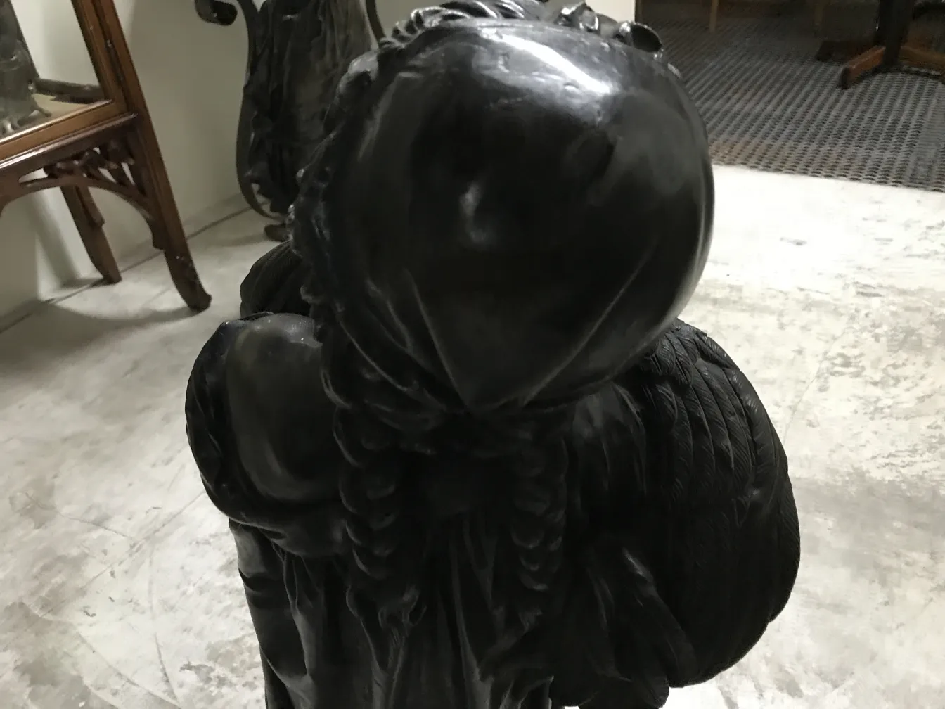 escultura antiga de figura com asas, em um ambiente clássico