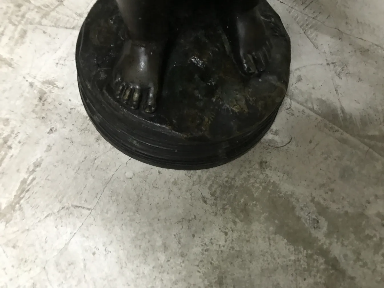 円形基台の上にある足のある古代彫刻