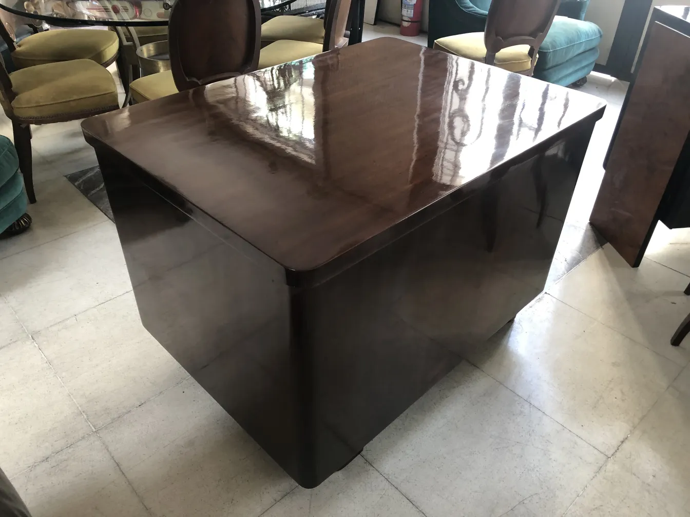 Escritorio antiguo de forma cuadrada, entorno con sillas variadas.