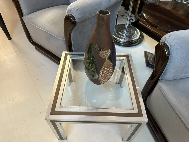 vaso de cerâmica antiga com decorações escuras, em mesa moderna