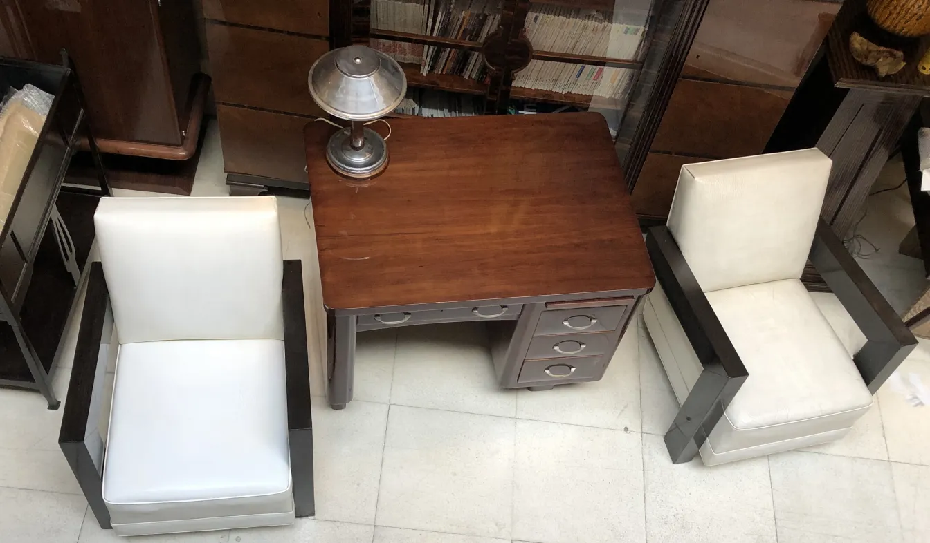 scrivania antica in legno con sedie bianche e lampada