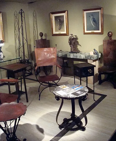 escultura antiga em um ambiente com móveis e pinturas