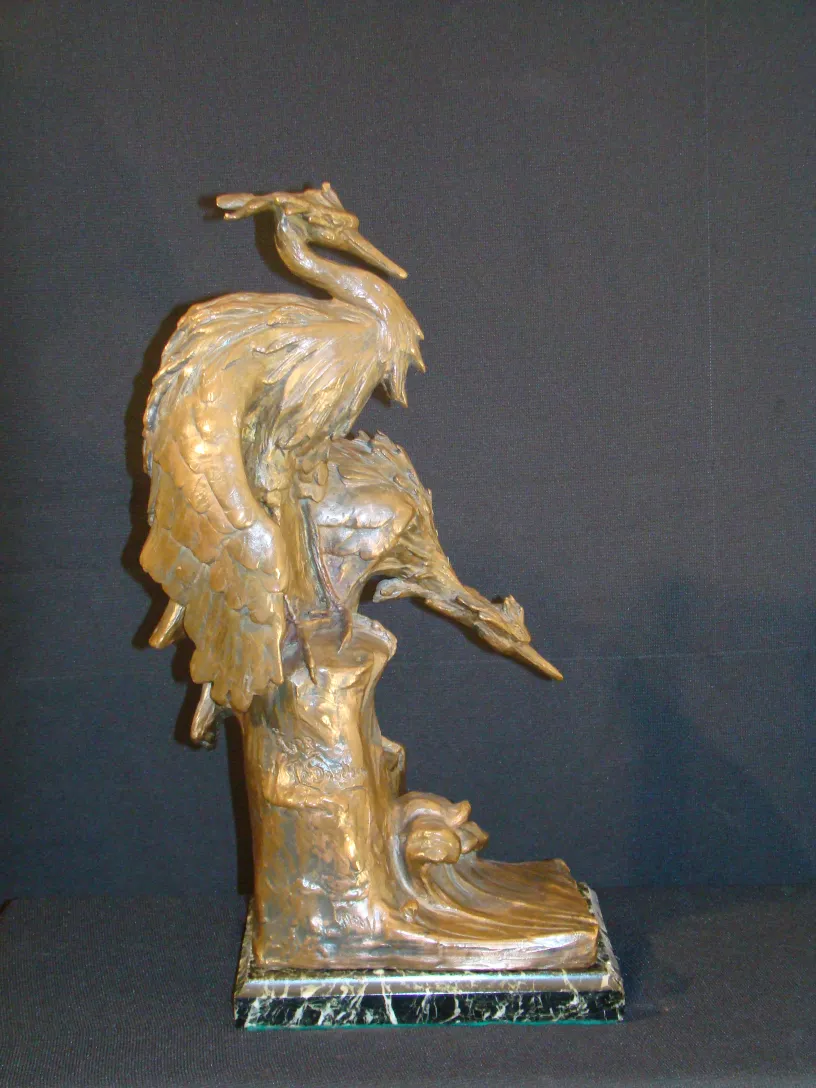 escultura antigua representa una grulla sobre un tronco