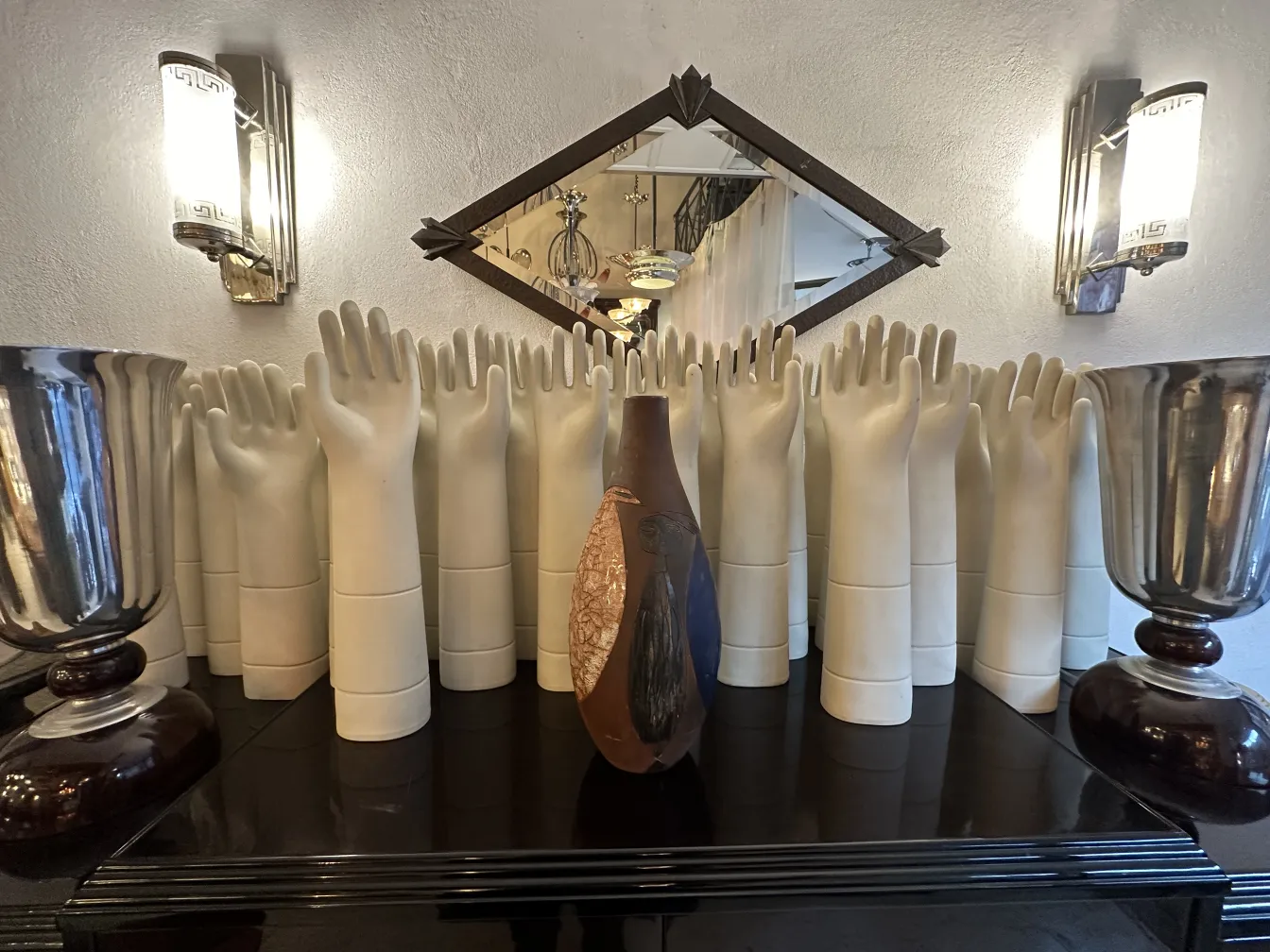 Ancienne céramique décorative dans diverses formes et couleurs, entourée de mains blanches