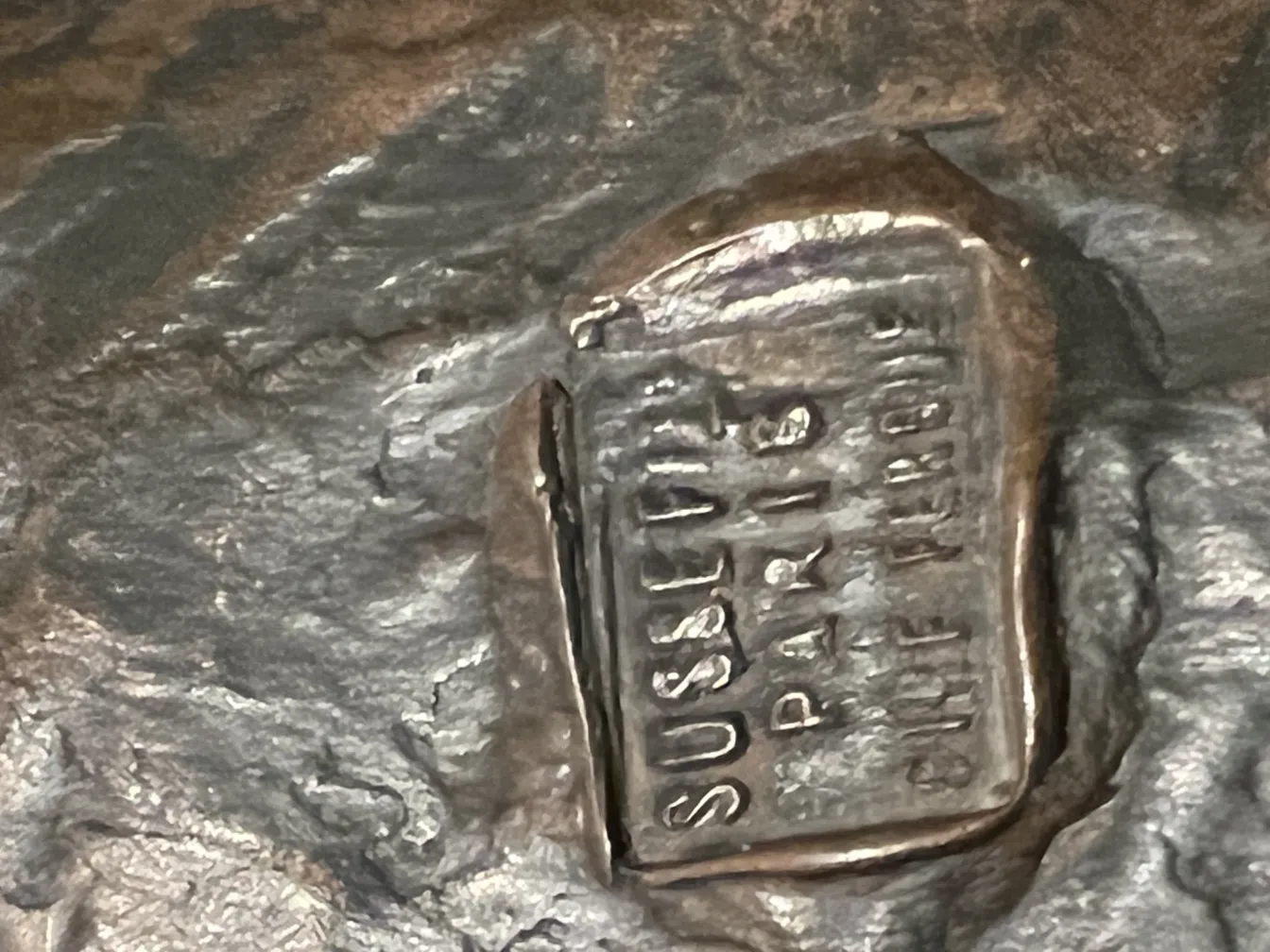 alte Skulptur mit strukturierter Oberfläche und Signatur