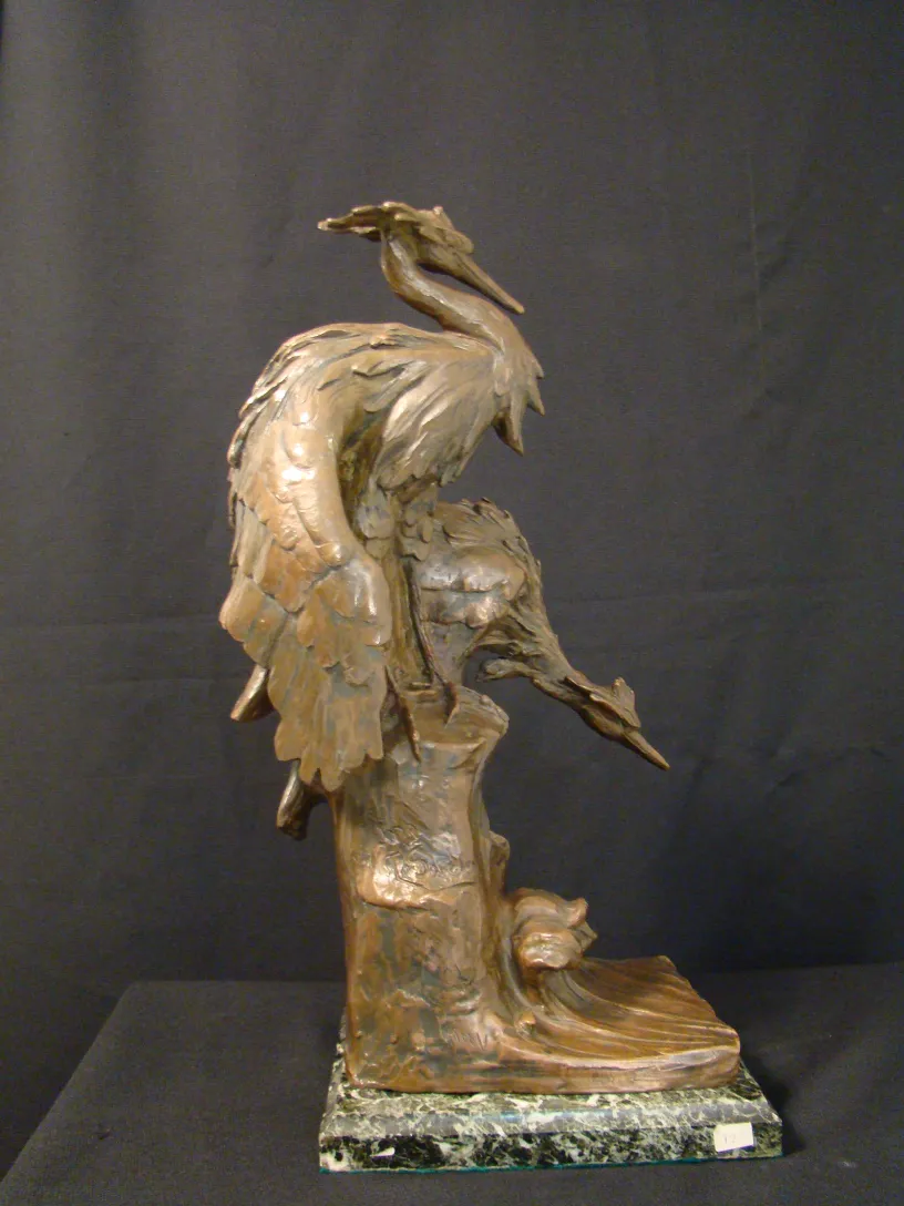 Sculpture antique d'oiseau sur un piédestal détaillé