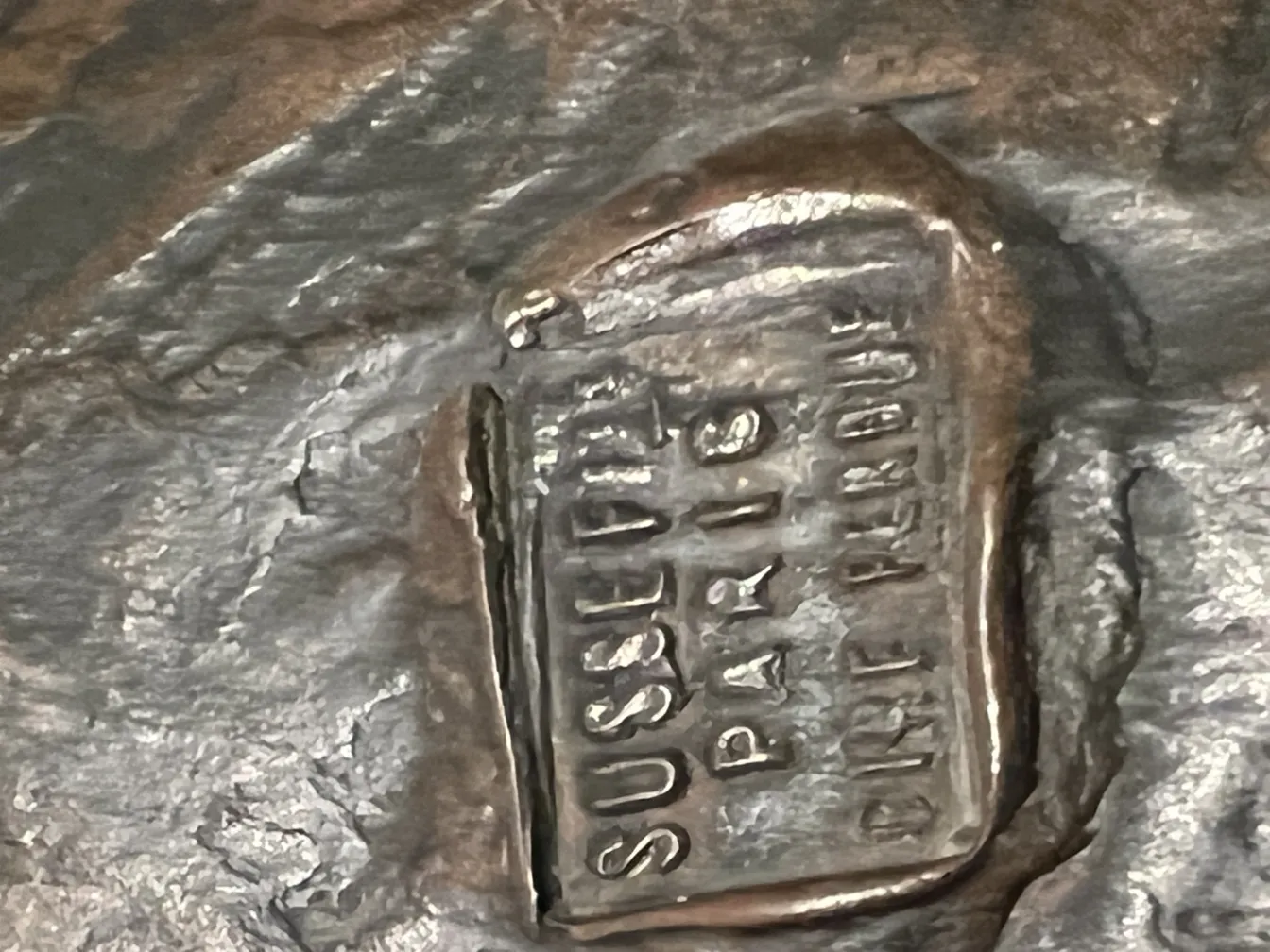 Detail der antiken Skulptur mit sichtbarer Signatur