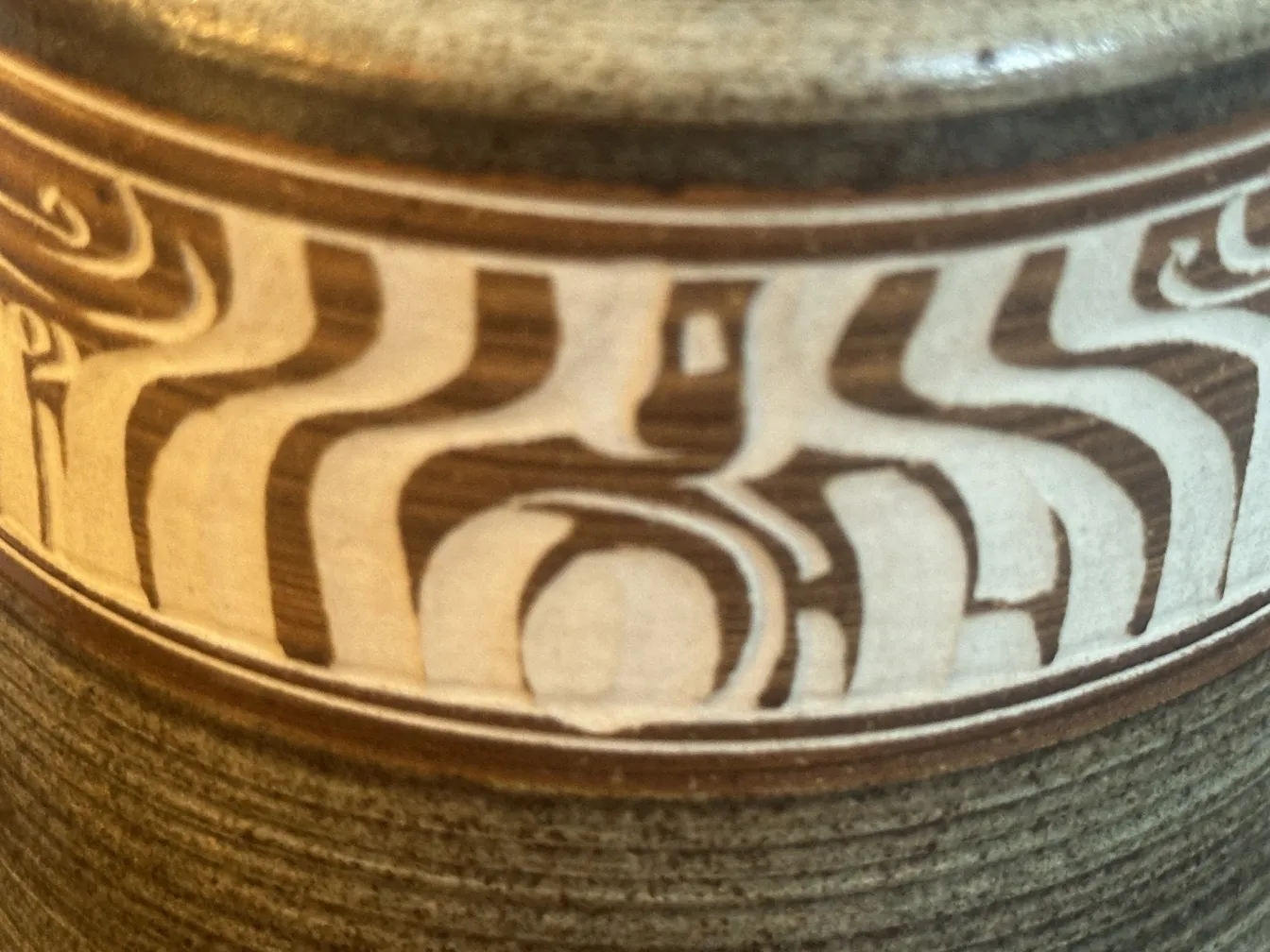 Cerámica antigua con diseño en tonos marrones y crema.