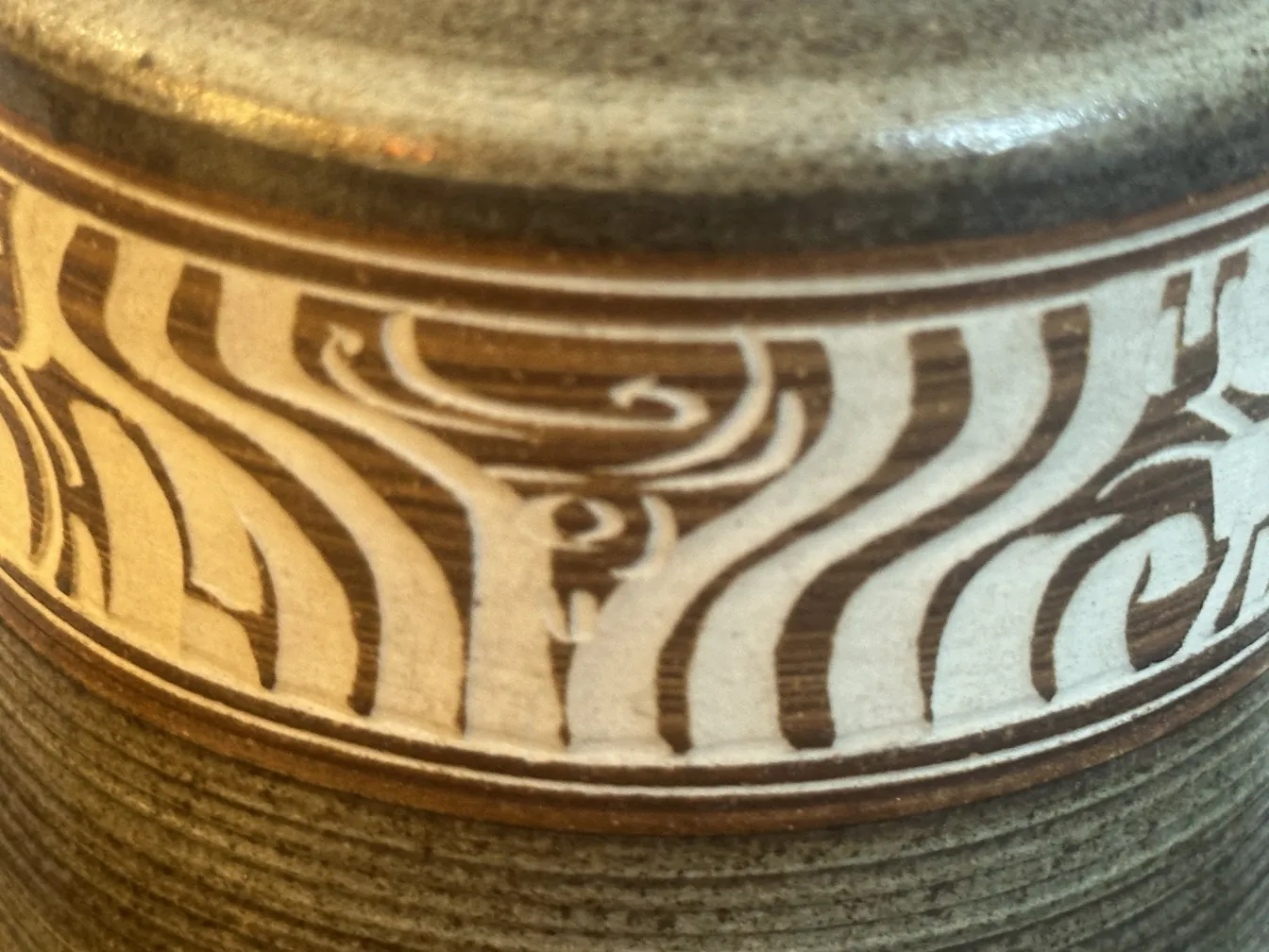 Antique ceramic decorated with abstract patterns in neutral tones.