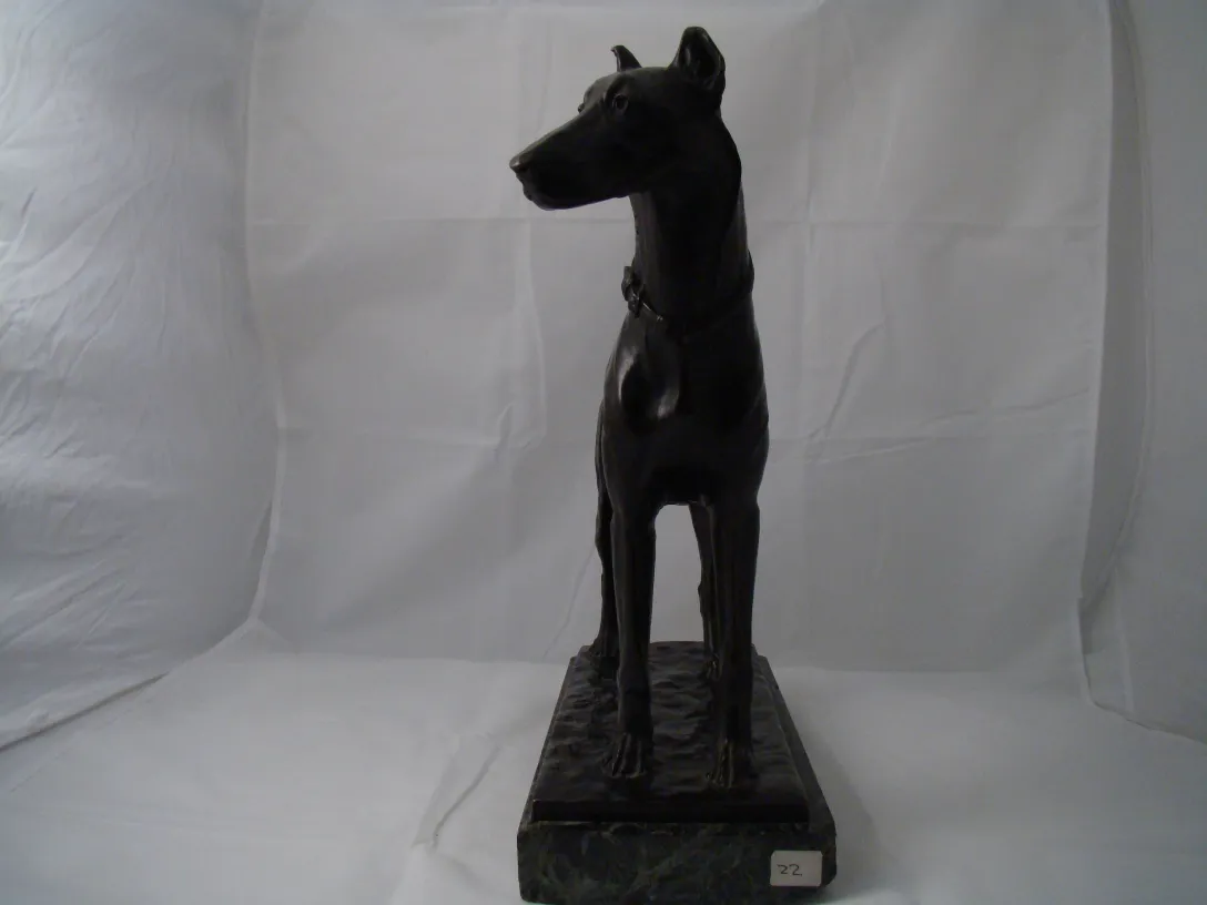 escultura de perro de perfil en base de mármol negro