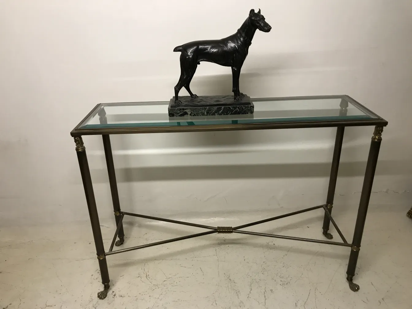 escultura antiga de cachorro preta sobre mesa de vidro